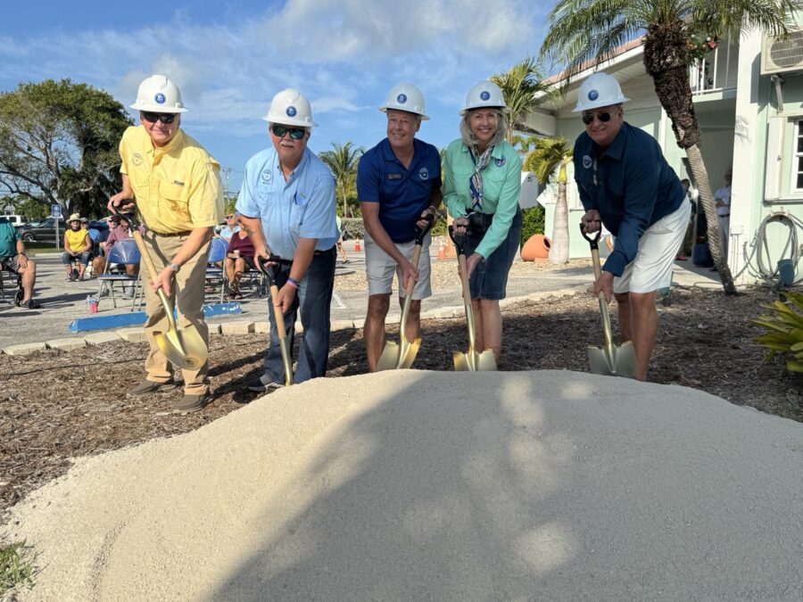 a group of men standing around a pile of sand
