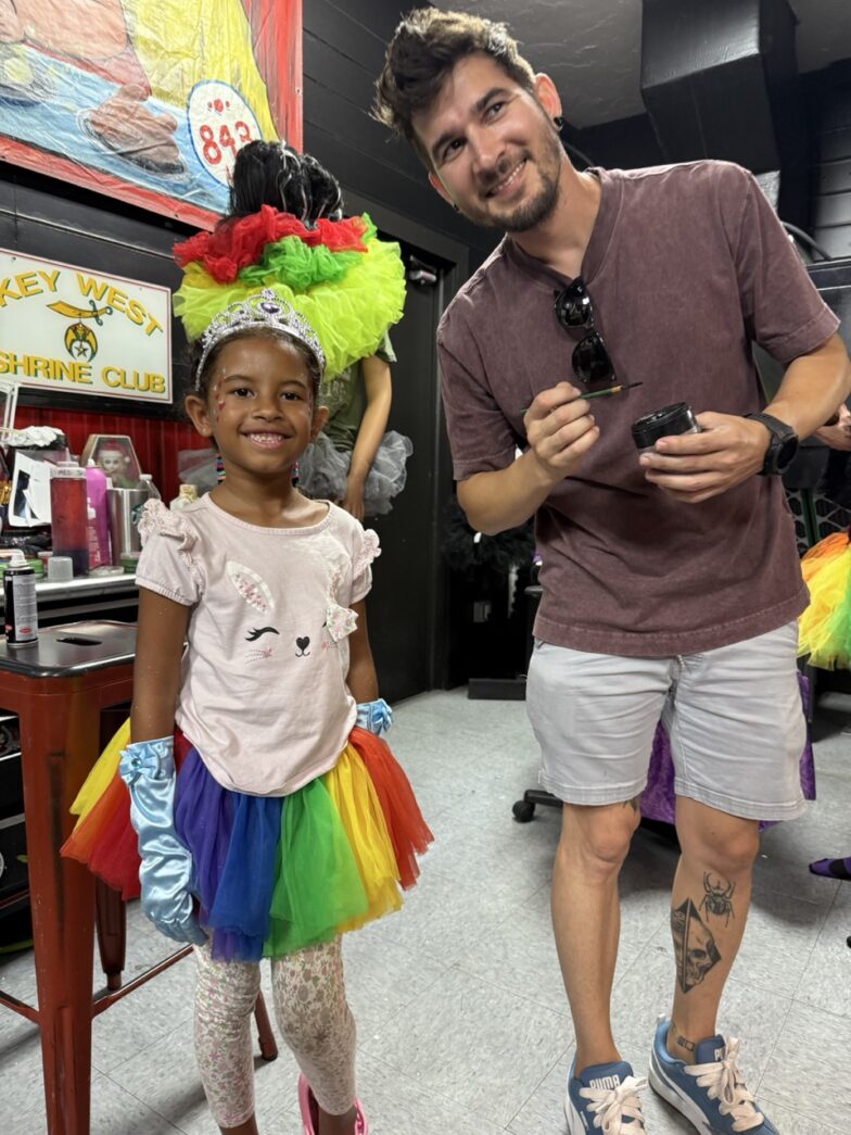 a man standing next to a little girl in a room