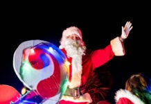 SANTA COMES TO ISLAMORADA THIS SUNDAY; SPECTATORS ENCOURAGED TO SUPPORT LOCAL TOY DRIVE a man dressed as santa claus waves to the crowd