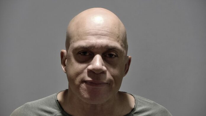 James Varner a man with a bald head wearing a gray shirt