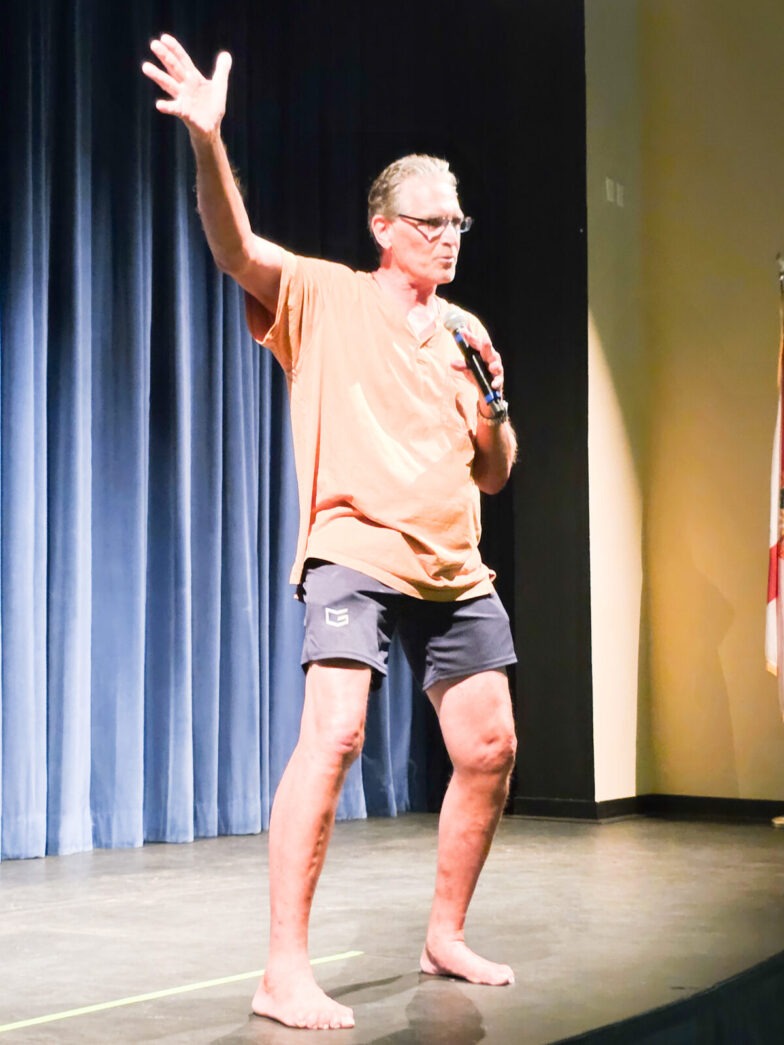 a man standing on top of a stage holding a microphone