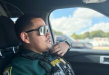a police officer sitting in the driver's seat of a car