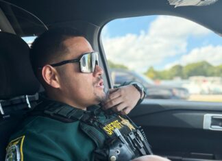 a police officer sitting in the driver's seat of a car
