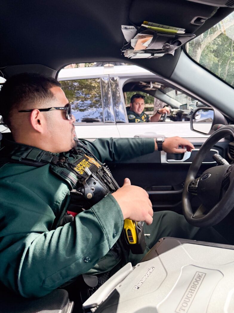 a man driving a car with a steering wheel