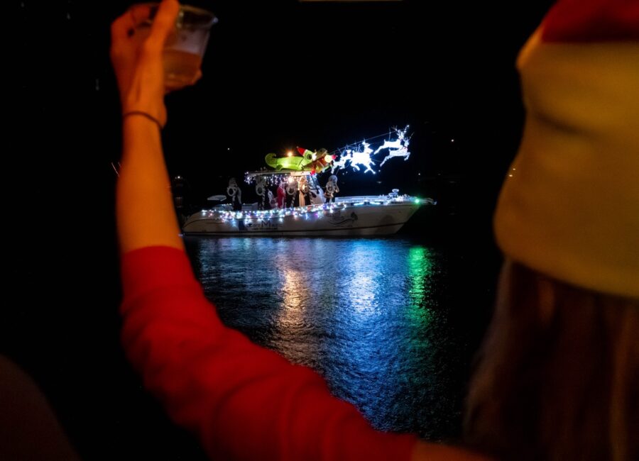 a woman taking a picture of a boat on the water