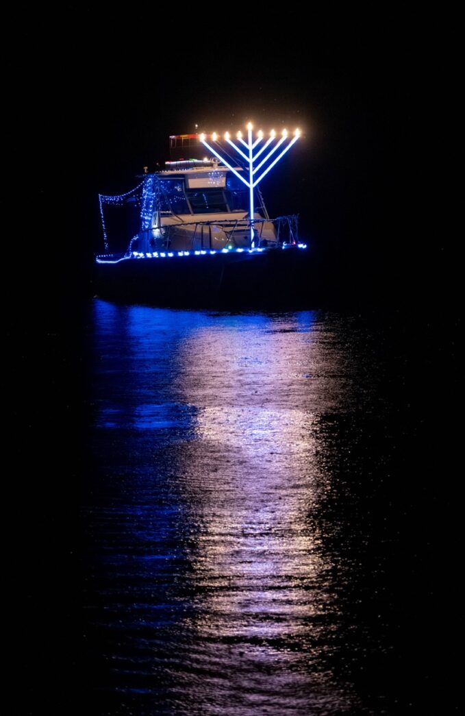 a boat with lights on it floating in the water