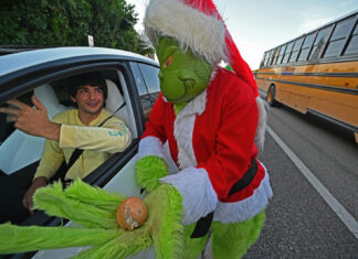 a man in a grin face costume getting out of a car