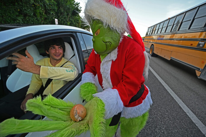 a man in a grin face costume getting out of a car