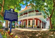 a red and white house with a sign in front of it