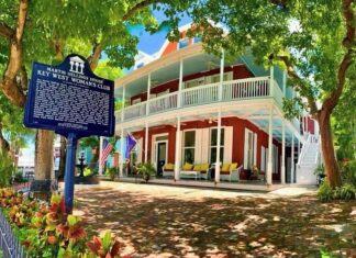 a red and white house with a sign in front of it
