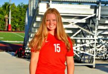 ATHLETE OF THE WEEK: MARY SEARCY a woman in a red shirt is posing for a picture