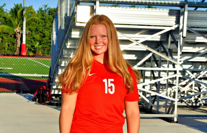 KWHS individual pics1-1 a woman in a red shirt is posing for a picture