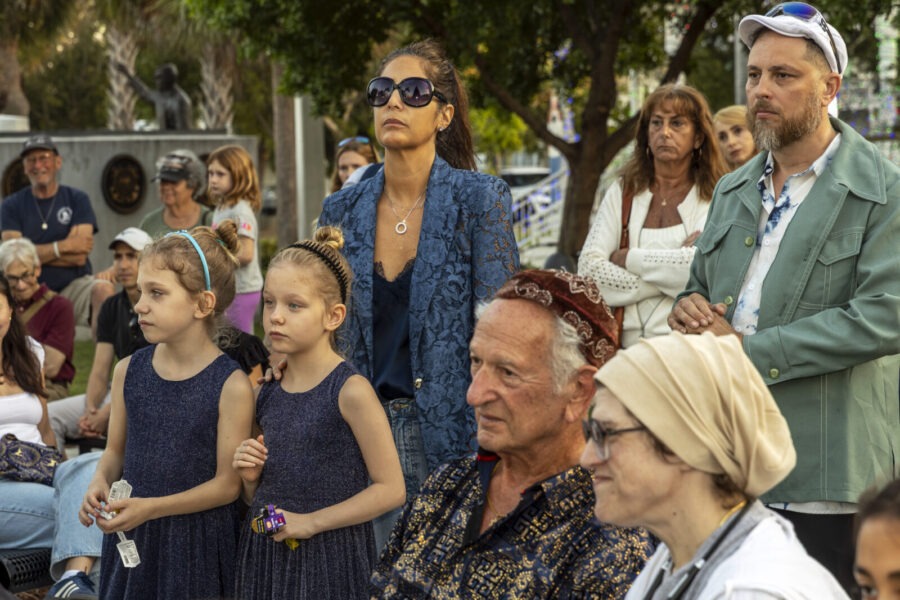 a group of people sitting in a park next to each other