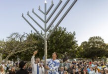 KEY WEST MENORAH LIGHTS THE DARKNESS a group of people standing around a menorah