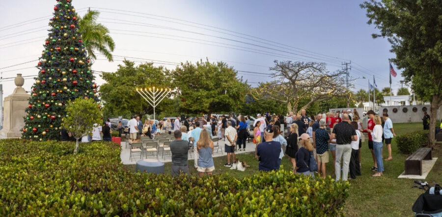 a group of people standing around a christmas tree