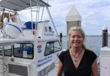 a woman standing on a dock next to a boat