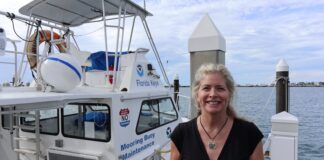 a woman standing on a dock next to a boat
