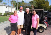 a group of people standing in front of a golf cart