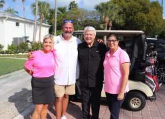 a group of people standing in front of a golf cart