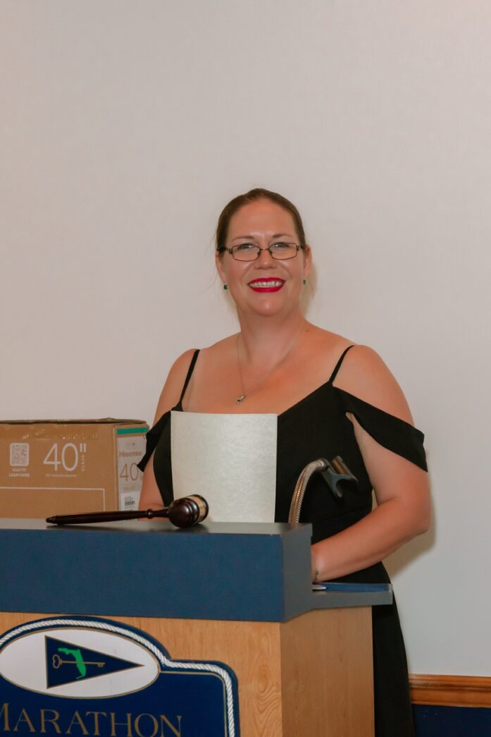 a woman standing at a podium with a piece of paper in her hand