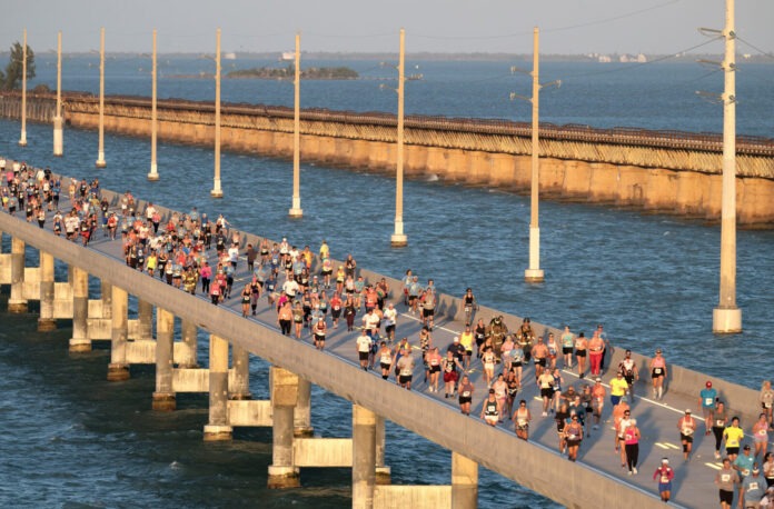 a large group of people running across a bridge