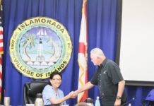 DON HORTON SELECTED ISLAMORADA MAYOR; COUNCIL DELAYS BASEBALL AGREEMENT WITH SCHOOL DISTRICT TO PROGRESS FOUNDERS FIELD UPGRADES a man shaking a woman's hand in front of flags