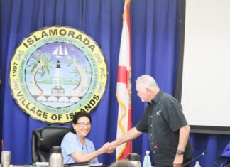 a man shaking a woman's hand in front of flags