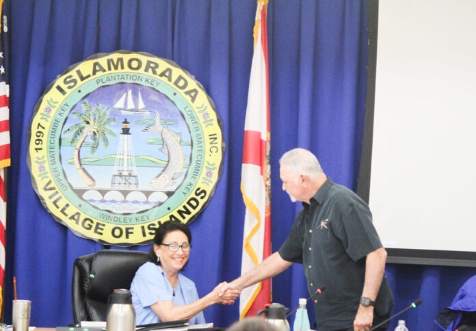 a man shaking a woman's hand in front of flags