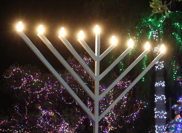 Menorah Lighting_C Tedesco_IMG_2539 a menorah is lit up in front of a christmas tree