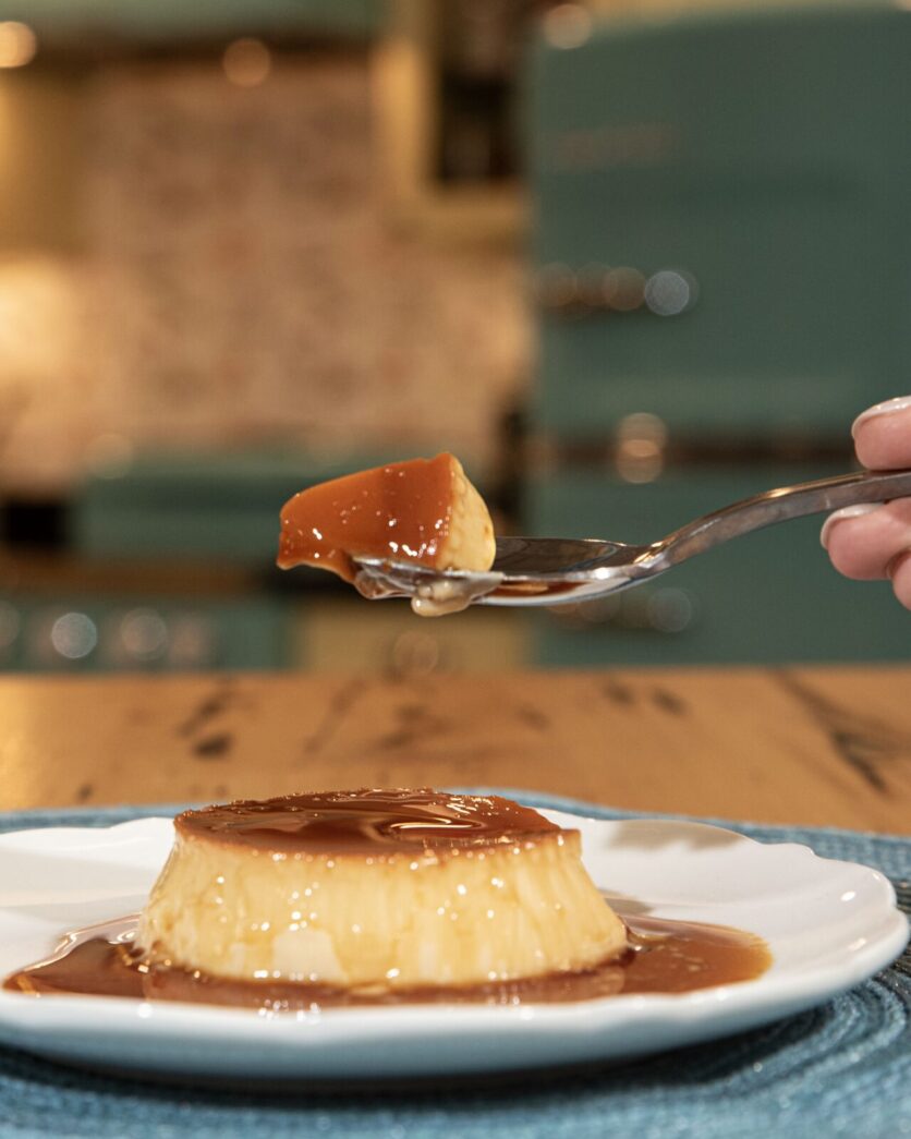 a person holding a spoon with a piece of cake on it