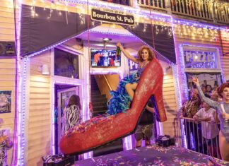 a group of people standing around a house