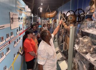 HISTORY OF DIVING MUSEUM TOURS HIGHLIGHT NAVY, PEARL HARBOR a group of people looking at items on display