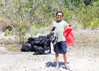 SHORELINE CLEANUPS HONOR THE LIFE OF PASCAL WEISBERGER a man standing in the dirt with a red bag