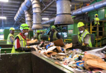 a group of men standing next to a pile of trash
