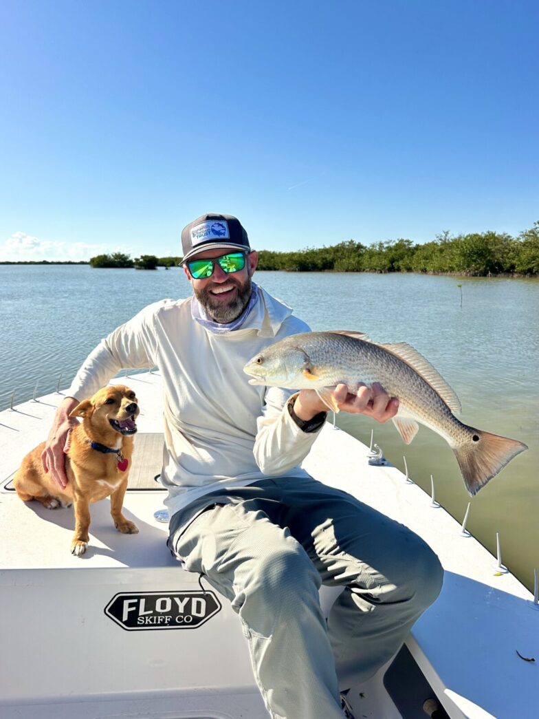 a man sitting on a boat holding a fish