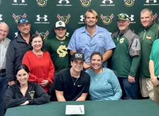 CORAL SHORES SENIOR RILEY O’BERRY TO PLAY COLLEGE BALL IN OKLAHOMA a group of people standing around a table