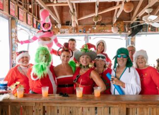 THIS WEEKEND: ENJOY COCKTAILS WITH THE CLAUS AT THE 2025 7 MILE SANTACON a group of people standing around a bar