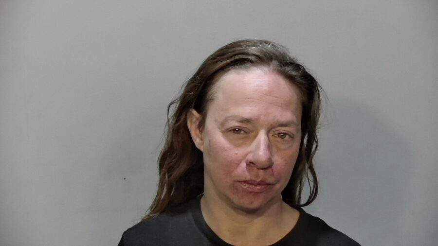 a mug shot of a woman in a black shirt