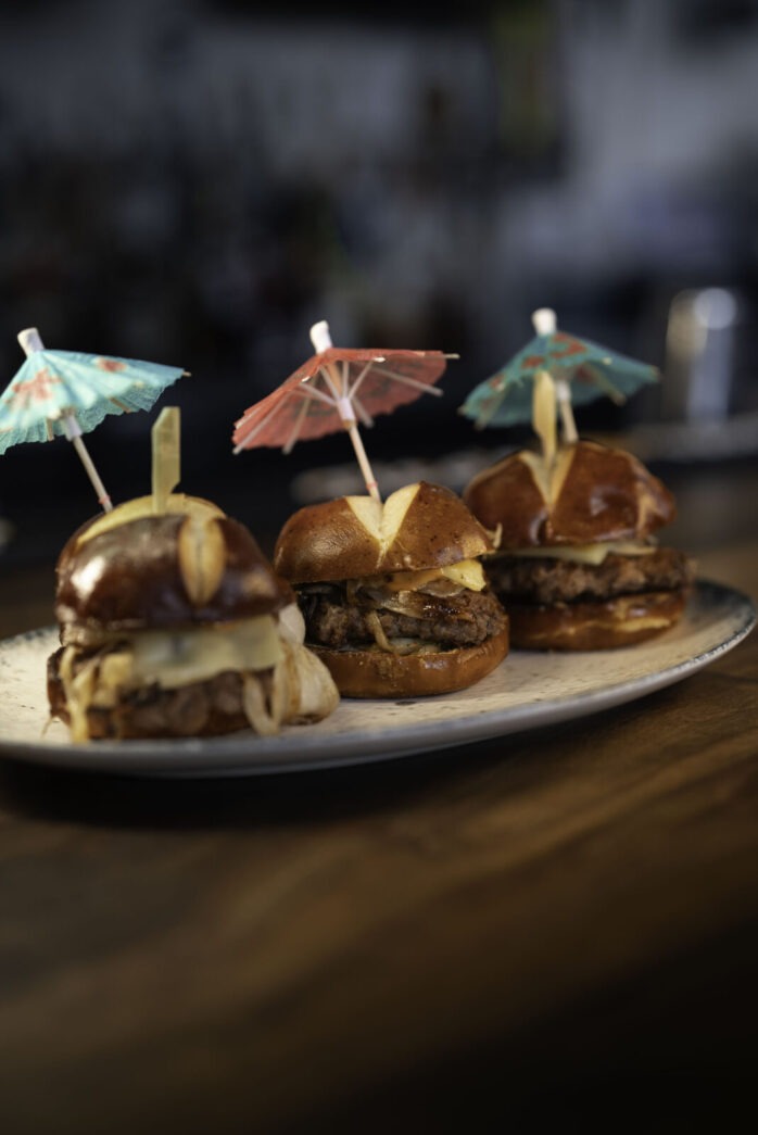 a plate topped with mini sandwiches and umbrellas