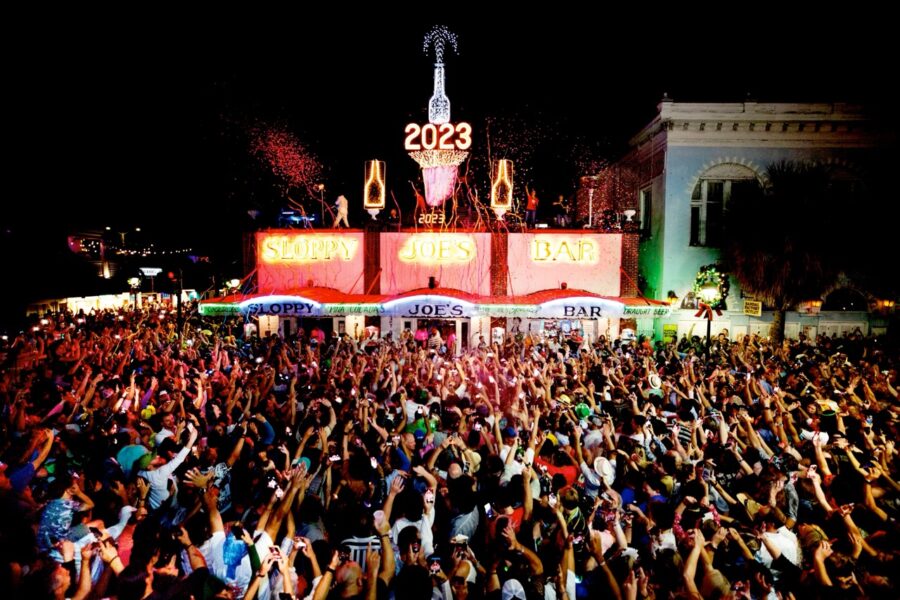 a crowd of people standing around a carnival at night