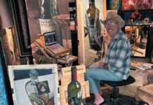 ARTIST THOMAS ARVID RETURNS TO KEY WEST GALLERY a man sitting in a chair next to a dog