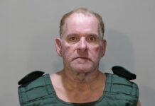 a mug shot of a man in a green shirt