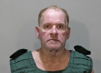 a mug shot of a man in a green shirt