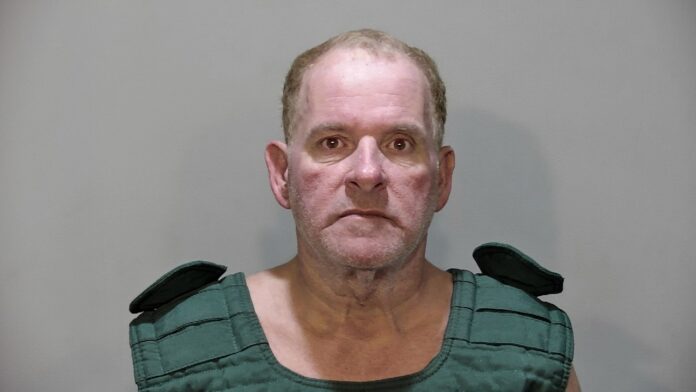 a mug shot of a man in a green shirt