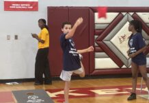 a group of young people standing on top of a basketball court