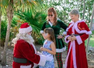 THIS WEEKEND: ENJOY ISLAND LIGHTS & A FESTIVE NIGHT AT THE PIGEON KEY HOLIDAY SPECTACULAR a group of people dressed up as santa claus
