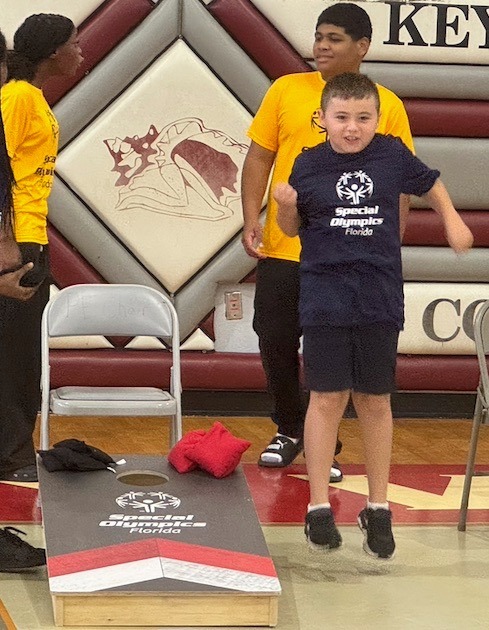 a group of young people standing on top of a hard wood floor