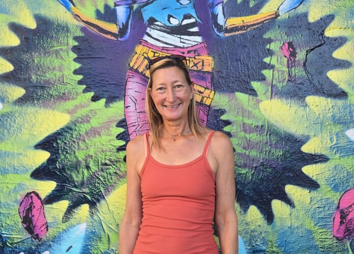a woman standing in front of a colorful wall