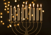 CHABAD OF KEY LARGO HOSTS COMMUNITY MENORAH LIGHTING a menorah with lit candles on a table