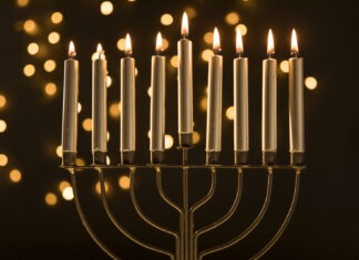 CHABAD OF KEY LARGO HOSTS COMMUNITY MENORAH LIGHTING a menorah with lit candles on a table